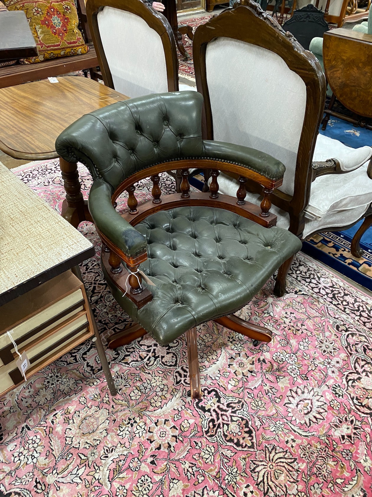 A reproduction buttoned green leather mahogany swivel desk chair, width 62cm, depth 56cm, height 85cm